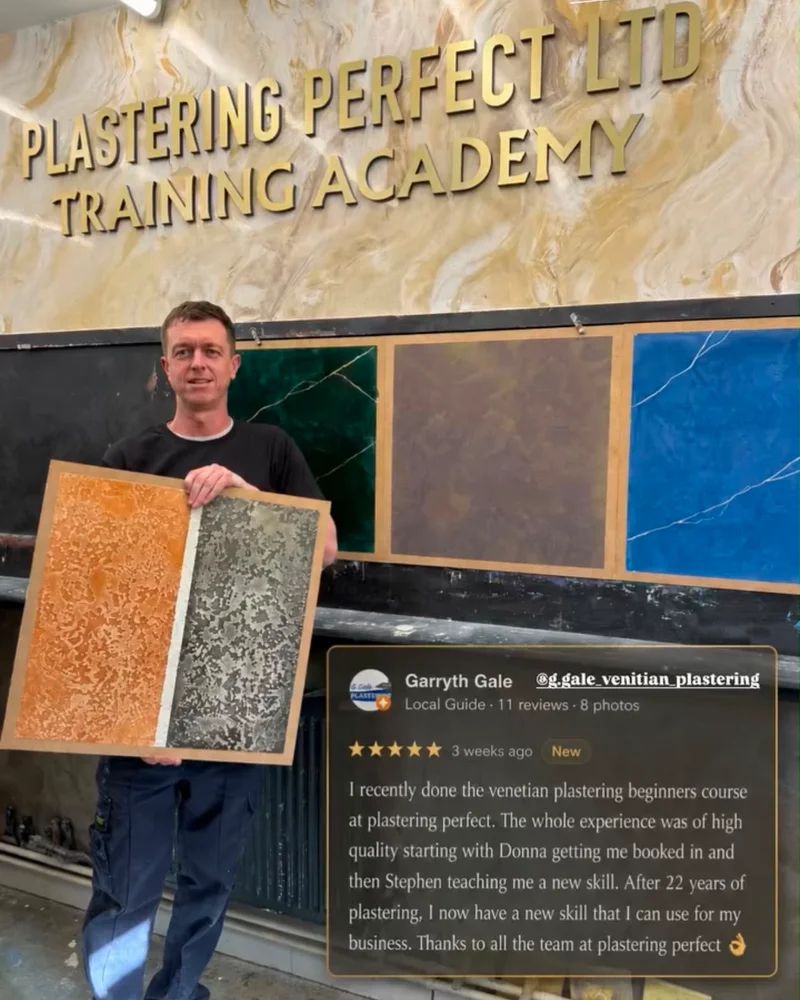 A trainee holding two finished sample boards at the training academy, with his five-star Google review: “I recently done the venetian plastering beginners course at plastering perfect. The whole experience was of high quality starting with Donna getting me booked in and then Stephen teaching me a new skill. After 22 years of plastering, I now have a new skill that I can use for my business. Thanks to all the team at plastering perfect.”
